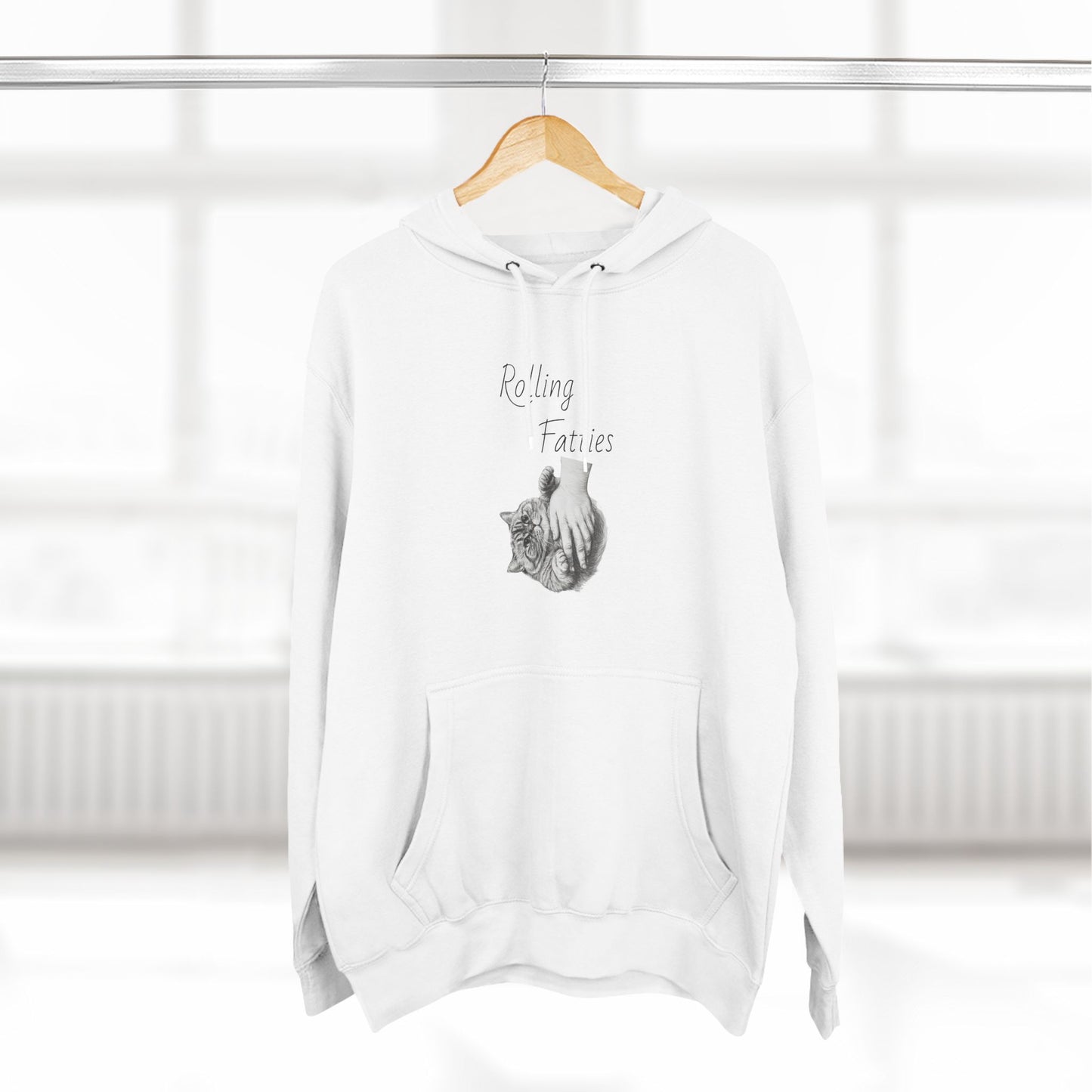 White Rolling Fatties Hoodie hanging on a wooden hanger in a bright room. A stylish and cozy addition to any wardrobe.